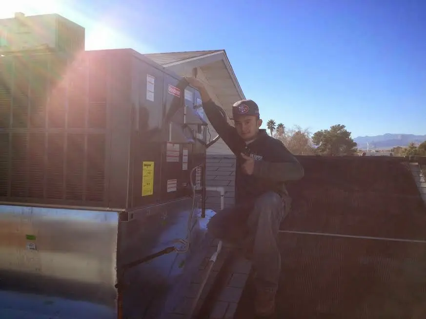 HVAC technician performing HVAC Inspection on a rooftop unit in North Kansas City